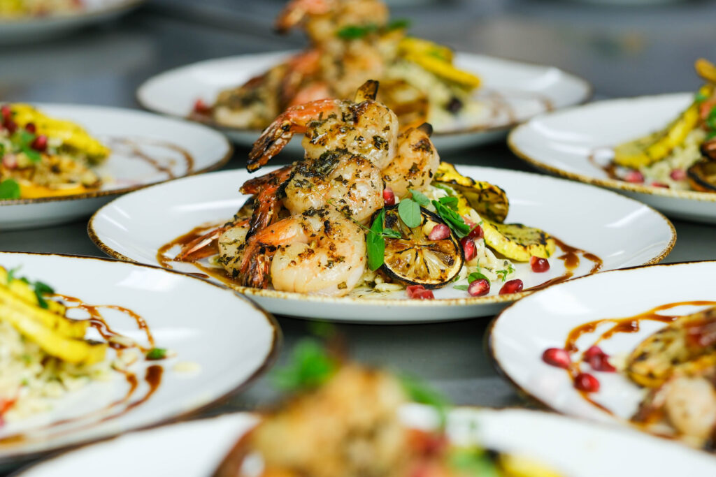 Grilled shrimp with charred lemon, orzo and summer squash prepared by Good Food Events + Catering in Tampa